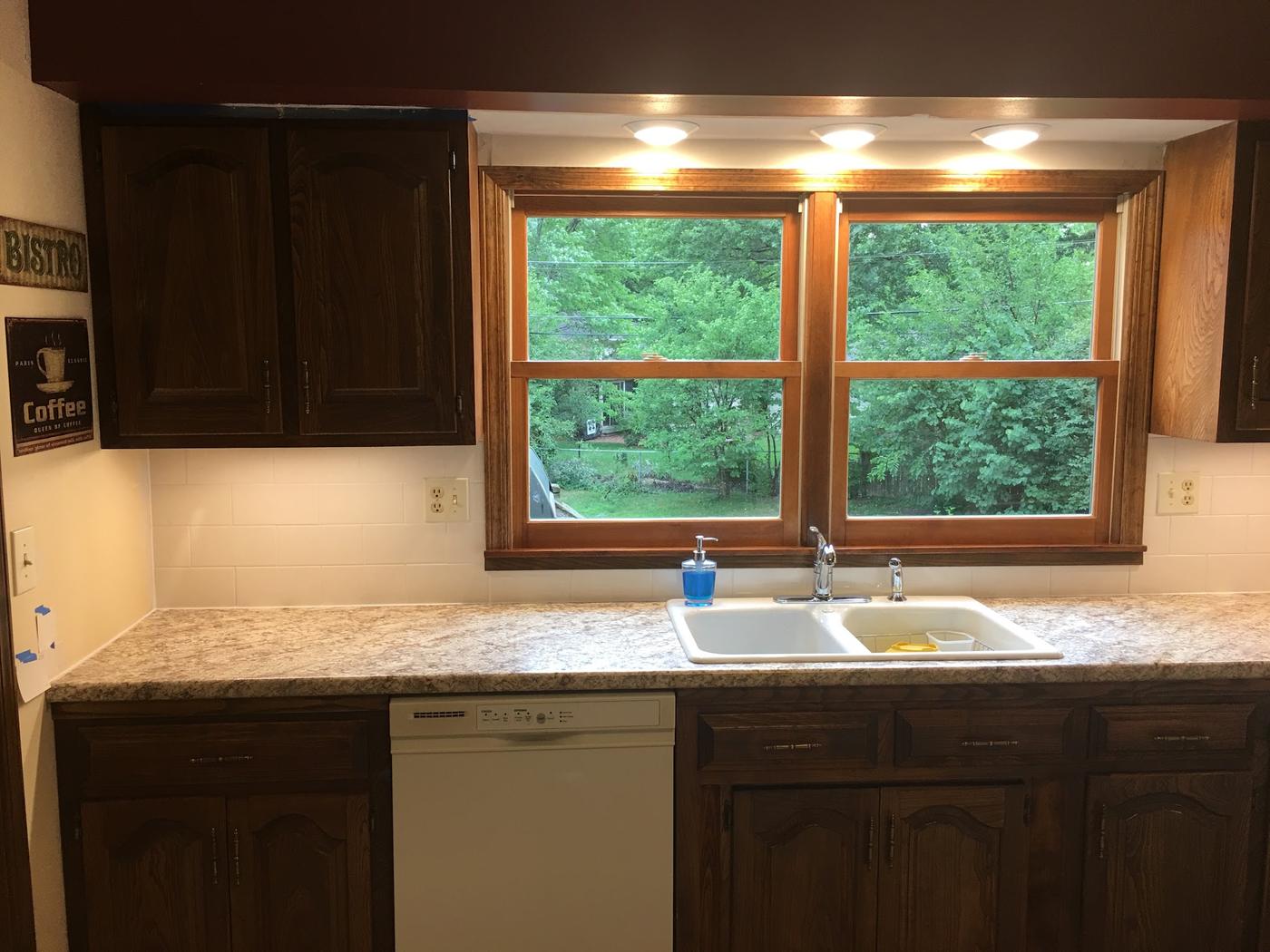 A kitchen with a new counter, drop-in double sink and faucet
